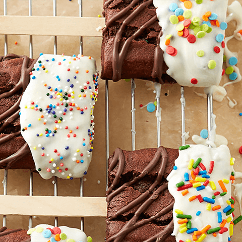 Close up of an iced brownie bar with sprinkles on top.