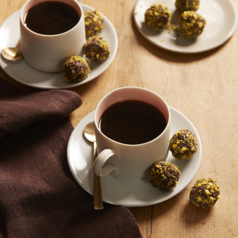 Cups of coffee with Nutty Brownies Bites, made with Fibre One™ 90 Calorie Chocolate Fudge Brownies, on the saucers